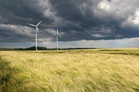 DunkleWolken über einem Feld mit einer Windkraftanlage