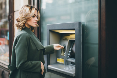 Frau hebt an Geldautomat Bargeld mit Girocard ab