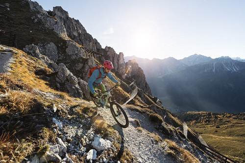 Unfallversicherung Test: Mountainbiker auf einem Trail in den Alpen