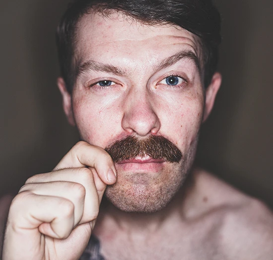 Wichtigste Vorsorgeuntersuchungen Männer: Mann mit Schnurrbart