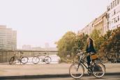 Frau fährt mit ihrem Fahrrad durch die Stadt