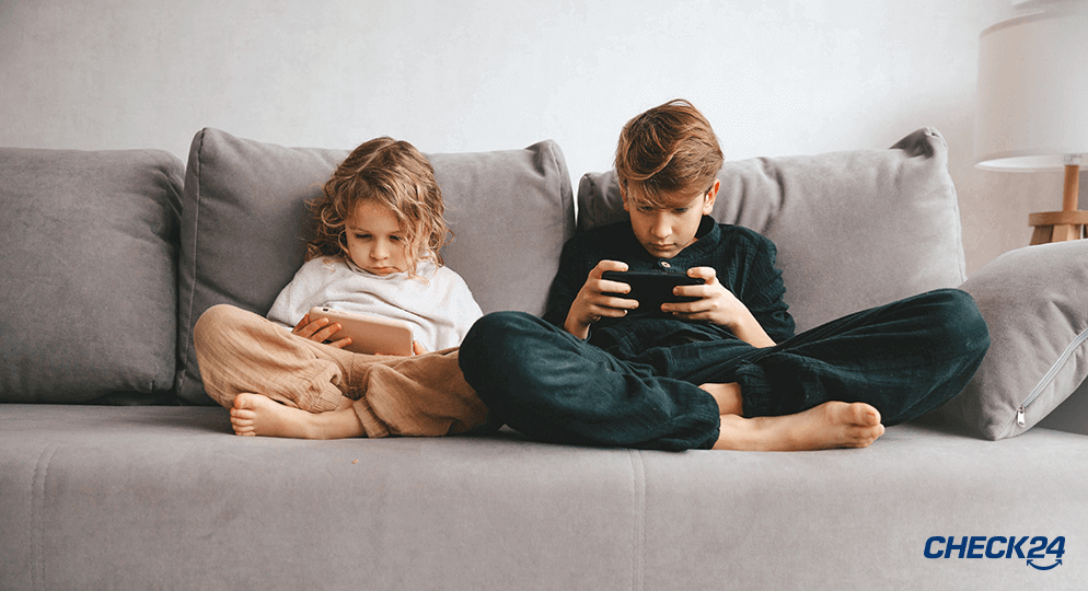 Kinder sitzen mit Smartphones auf der Couch