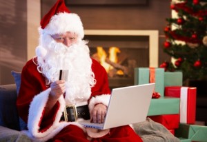 Weihnachtsmann beim Onlineshopping mit Kreditkarte