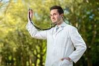 Arzt mit Stethoskop vor Landschaft