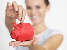 Tagesgeld: Frau wirft Geldstück in Sparschwein