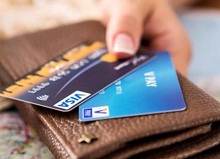 Mann hält zwei Visa-Kreditkarten