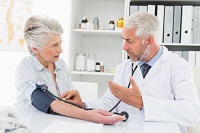 Arzt misst Blutdruck bei Patientin