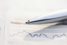 Stift liegt auf Unterlagen, die eine Zinskurve zeigen