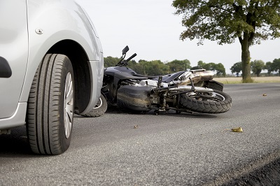 Ein defektes Motorrad liegt nach einem Zusammenprall mit einem Pkw auf der Straße.