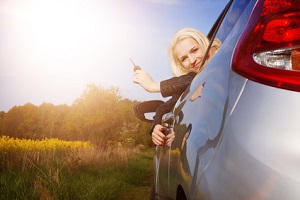 Frau mit Schlüssel in der Hand sitzt im Auto
