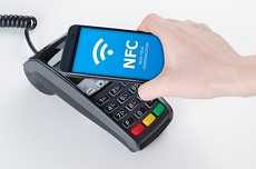Lesegerät darüber ein Smartphone auf dessen Bildschirm NFC-Symbol zu sehen ist
