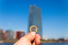 EZB-Gebäude in Frankfurt mit Euro-Münze