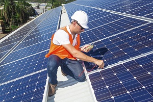 Handwerker installiert Solaranlage auf Dach
