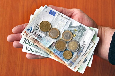 Hand mit Geldscheinen und Euro-Münzen