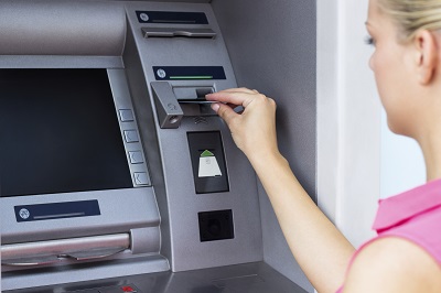 Frau hebt Geld am Automaten ab