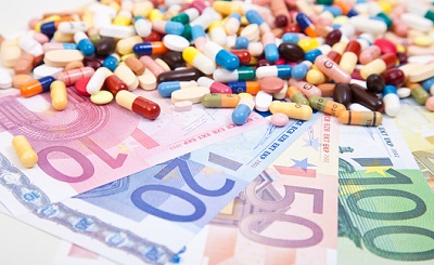Viele Tabletten liegen auf Euro-Geldscheinen.