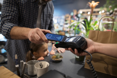 An einem NFC-Terminal können Kunden mit dem Smartphone bezahlen.