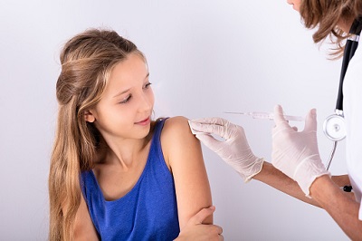 Mädchen erhält Impfung von einer Ärztin