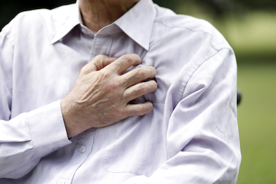 Älterer Mann mit Herzschmerzen greift sich an die Brust.