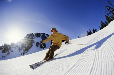 Mann fährt Ski auf einer Piste.