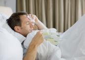 Kranker Mann (mit Grippe) im Bett
