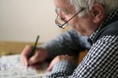 Älterer Mann löst ein Kreuzworträtsel