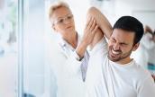 Eine Ärztin behandelt einen Patienten wegen Rückenschmerzen.