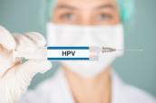Krankenschwester hält eine Spritze mit Aufschrift "HPV".