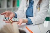 Ärztin hält drei Tabletten in der Hand
