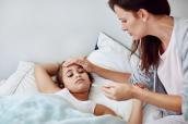 Mutter misst Temperatur bei kranker Tochter mit Fieber