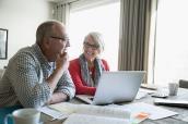 Rentner-Paar macht seine Finanzen am Laptop.
