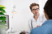 Arzt führt im Sprechzimmer ein Gespräch mit einem Patienten.