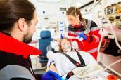 Sanitäter verarzten Frau im Rettungswagen
