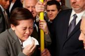 Niesende Geschäftsfrau in U-Bahn mit anderen Passagieren