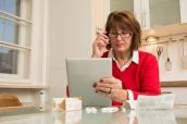 Ältere Frau mit Medikament, Beipackzettel und Tablet
