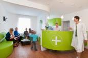 Arztpraxis: Empfang mit wartenden Patienten und Ärztin