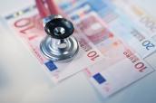 Stethoskop liegt auf Euro-Geldscheinen.