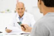 Ein Patient reicht seinem Arzt eine Kreditkarte.