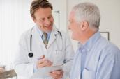 Arzt spricht mit einem älteren Patienten.