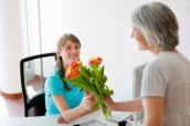 Patientin schenkt Arzthelferin einen Blumenstrauß
