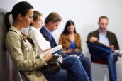 Patienten sitzen im Wartezimmer einer Arztpraxis.