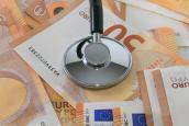 Ein Stethoskop liegt auf einigen 50 Euro Scheinen.