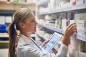Apothekerin vor Medikamentenschrank