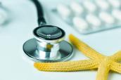 Stethoskop mit Seestern und Tabletten im Hintergrund