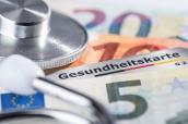 Gesundheitskarte mit Banknoten und Stethoskop