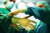 Arzt zieht Handschuh im OP an
