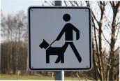 Verkehrsschild eines Hundehalters mit Hund an der Leine