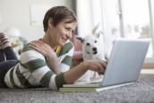 Frau mit Hund vor einem Computer