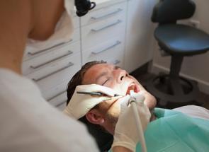 Zahnärztin behandelt Patienten im Behandlungsstuhl.
