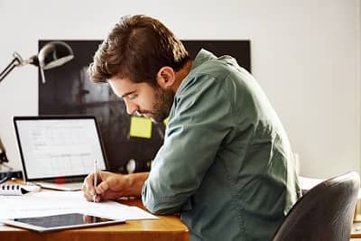 Junger Arbeitnehmer sitzt am Schreibtisch